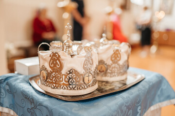 Two wedding crowns in the church. Golden crowns lie on the table in the church