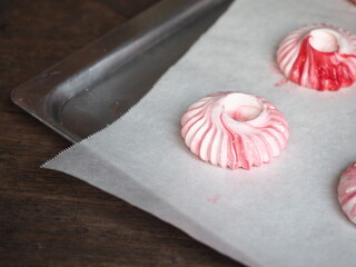 swirl ring shaped of red and white meringue cookie on baking paper