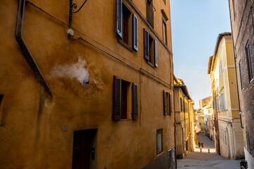View on narrow and cozy street in the old town of Siena city in Italy. Concept of ancient architecture of the Tuscan region