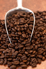 cuillère remplie de grains de café torréfié 