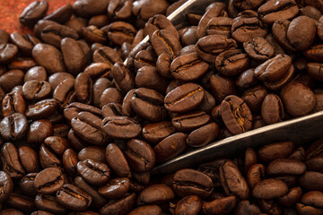 cuillère remplie de grains de café torréfié 