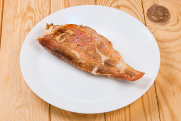 Baked ocean perch with sour cream sauce on a dish