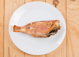 Baked redfish with sour cream sauce on dish, top view