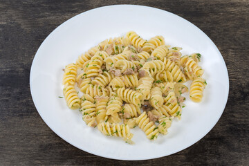 Prepared spiral pasta with chopped meat and dill on dish