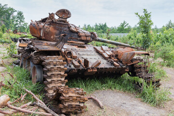 Fototapeta na wymiar Russian tank destroyed on forest edge, invasion of Ukraine, 2022