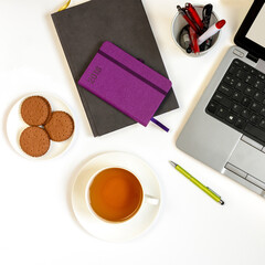 cup of tea, notebook and pen on the table