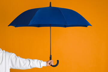 Woman with open blue umbrella on orange background, closeup © New Africa