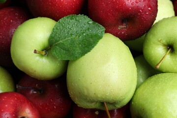 Fresh ripe green and red apples with water drops as background, top view
