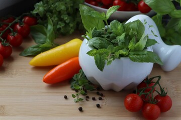 Mortar with different fresh herbs and pepper on wooden table, closeup