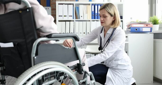 The doctor hits knees woman in a wheelchair with a hammer