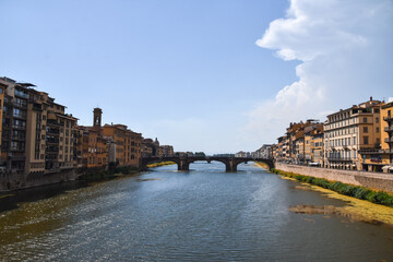 Fototapeta premium Fotografía en vertical del río de Florencia desde el Ponte Vecchio con las casas a los lados en Italia.
