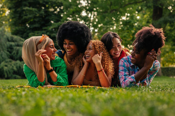 Happy girls lying on grass in park