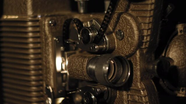 Close up on a vintage 8mm Projector with film running through it 4K