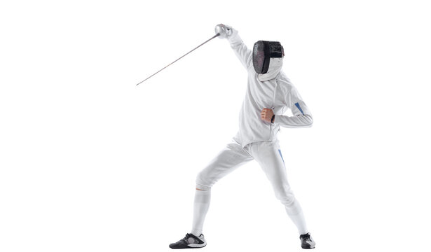 Dynamic portrait of young man, fencer in in fencing costume with sword in hand training isolated on white studio background. Sport, energy, skills
