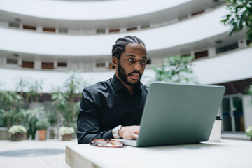 Young businessman working on his laptop in a hall