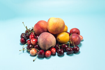 A set of fresh fruits bananas, cherries, nectarines, apricots, peaches on a bright blue background close-up.