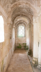 Ventana con celosía en arco de medio punto en pasillo de iglesia románica de piedra