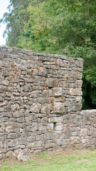 Fototapeta na wymiar Muro de piedra antiguo en zona verde