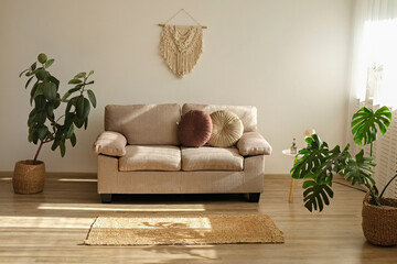 Minimalistic image, beige textile couch with round cushions over the blank wall background with a...