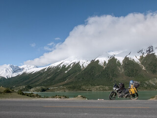 Fototapeta na wymiar Touring motorcycle and snow covered mountains