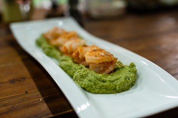 fried prawns on sweet potato puree.