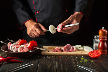 Cooking meat kebab with lamb in the kitchen of the restaurant by the hands of the chef. The idea of a delicious lunch for Caucasian cuisine.