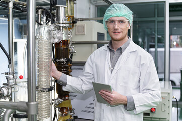 Inspector caucasian scientists are in the machine room extracting oil and cannabis seeds	