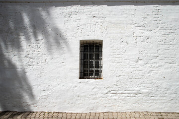 Prison cell window with bars, old stone citadel architecture detail. Window of an old prison on a...
