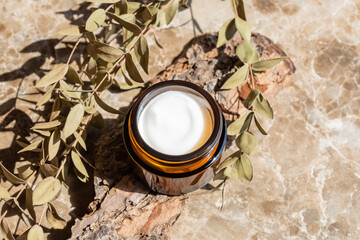 close up of collagen cream in glass jar and dry eyqalyptus on beige background. skin and body care beauty products. Mockup