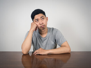 Depressed man sit at table thoughtful something