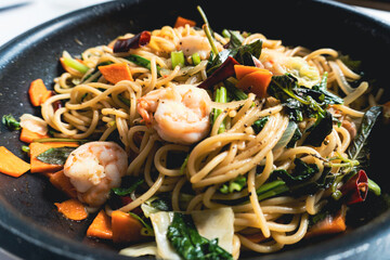 Spaghetti seafood with vegetables on the pan.