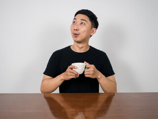 Positive man smile and hold coffee cup looking up