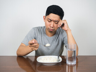 Depressed man feels bored food crying don't want to eatting rice on the table