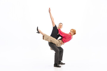 Portrait of stylish young couple, man and woman dancing isolated over white studio background. Rock and roll dance