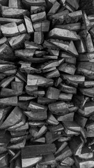 A large wall of stacked firewood. Black and white photo. High-quality photo