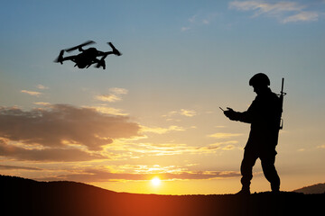 Obraz na płótnie Canvas Silhouette of soldier are using drone and laptop computer for scouting during military operation against the backdrop of a sunset. Greeting card for Veterans Day, Memorial Day, Independence Day.