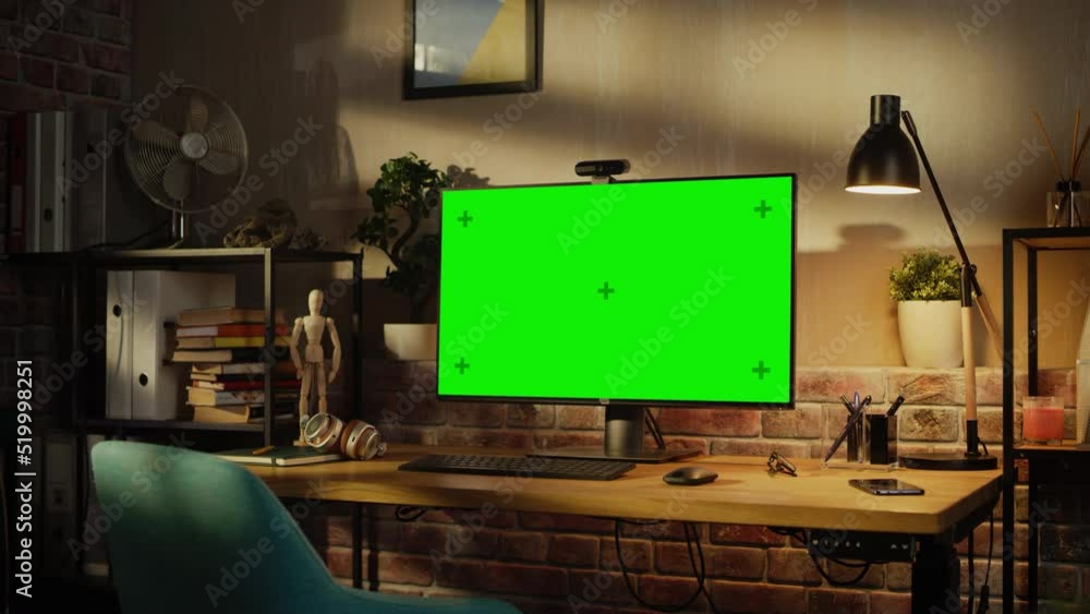Poster zoom in on a modern personal computer monitor with chroma key green screen display standing on the d