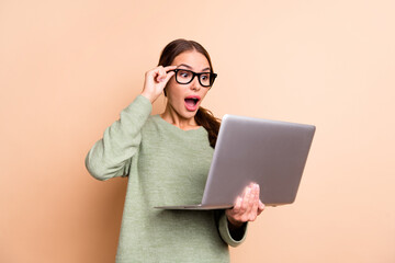 Photo of adorable impressed lady wear green sweater arm spectacles reading modern gadget isolated beige color background