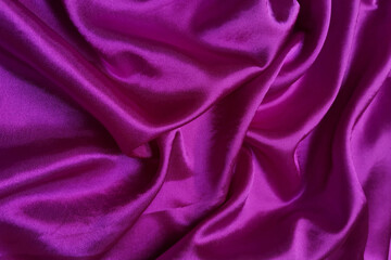 Pink crepe satin crumpled or wavy fabric texture background. Abstract linen cloth soft waves. Silk fabric. Smooth elegant luxury cloth texture. Concept for banner or advertisement.