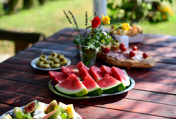 Sliced watermelon and food on a picnic table 