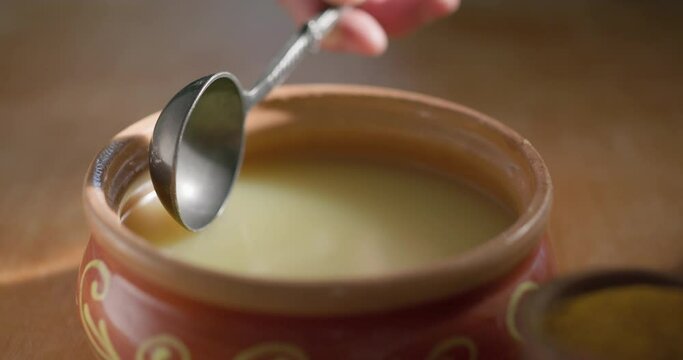 .Pure OR Desi Ghee also known as clarified liquid butter. Pure OR Desi Ghee in ceramic bowls on an old wooden table.