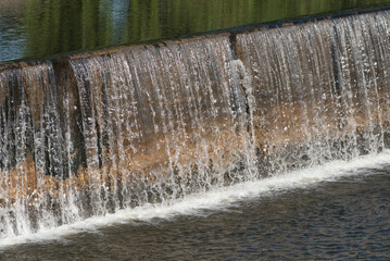 The water flow pass the weir from upper level to lower level.Water flow very fast in rainy season.