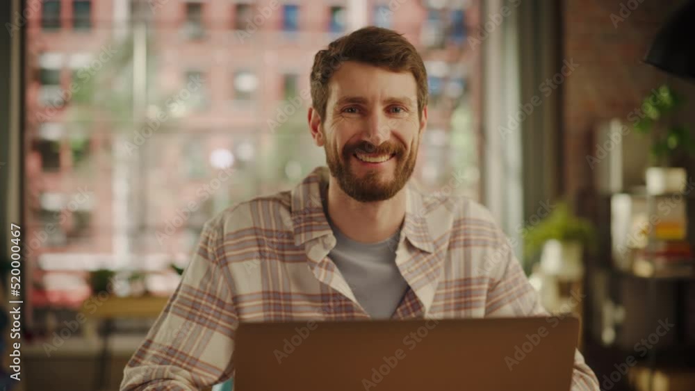 Poster portrait of a happy handsome caucasian man working on laptop computer in stylish cozy living room. f