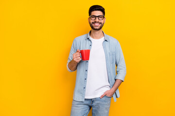 Photo of friendly latin young man relaxing have free time coffee cup wear trendy denim look eyewear isolated on yellow color background