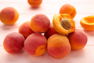 Fresh apricots on a pink wooden background.