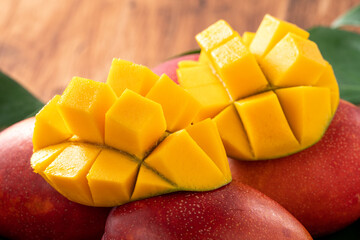 Mango. Fresh mango fruit with leaves over dark wooden table background.