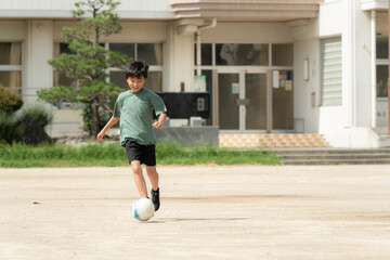 学校でサッカーをしている小学生の男の子 © tatsushi