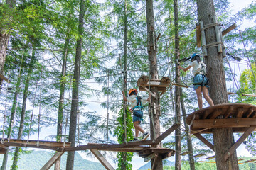 夏休みにアスレチックで遊ぶアジア人の小学生