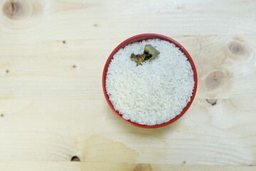 Healthy food. red ceramic bowl with high carb rice on wooden background. Top view, high resolution product.