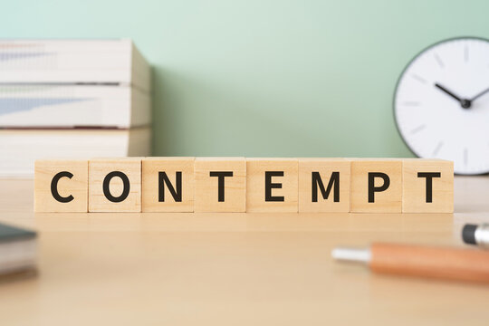 軽蔑・侮辱罪のイメージ｜「CONTEMPT」と書かれたブロックが置かれたデスク
